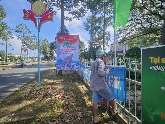 Những chiến binh thầm lặng treo cờ phướn chào mừng Kỷ niệm 70 năm tập kết ra Bắc trên địa bàn huyện Thới Bình.