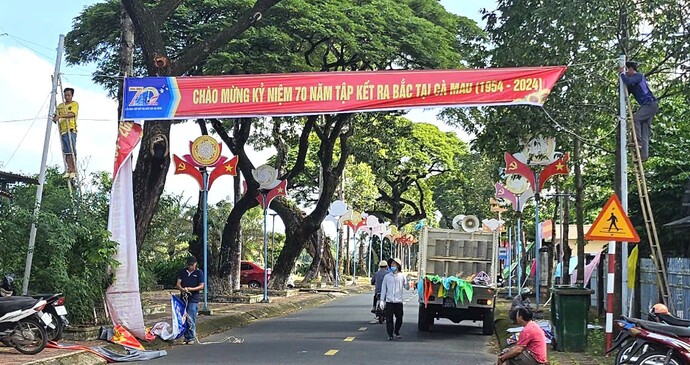 Những chiến binh thầm lặng bắt thang leo cao treo từng tấm băng gol chào mừng Kỷ niệm 70 năm tập kết ra Bắc trên địa bàn huyện Thới Bình.