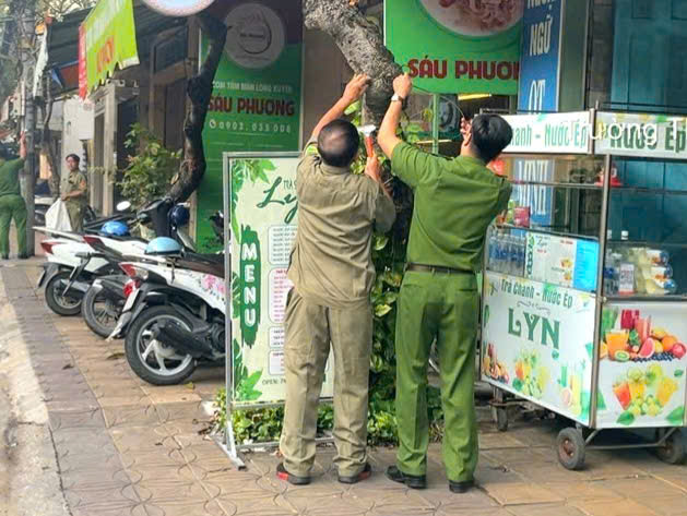 Lực lượng Công an phường Thới Bình xóa các quảng cáo không đúng nơi quy định.