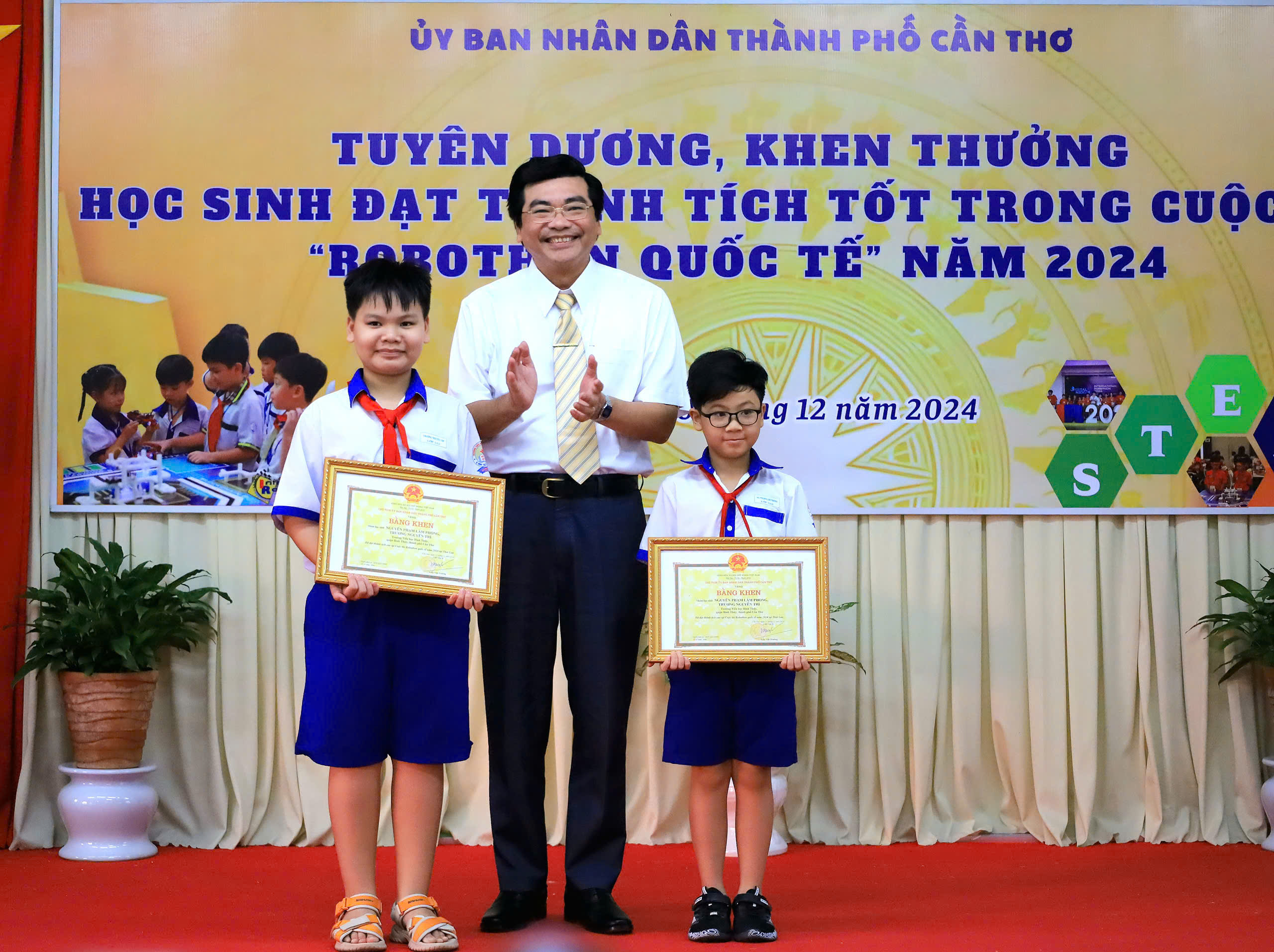 Ông Trần Thanh Bình - Giám đốc Sở GD&ĐT TP. Cần Thơ trao tặng Bằng khen của Chủ tịch UBND TP. Cần Thơ cho các em học sinh.