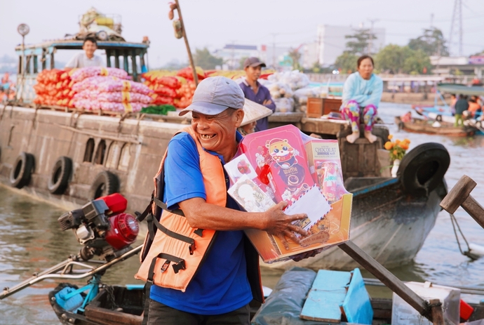 Tiểu thương chợ nổi Cái Răng phấn khởi nhận quà Tết. Ảnh: Phương Trọng.