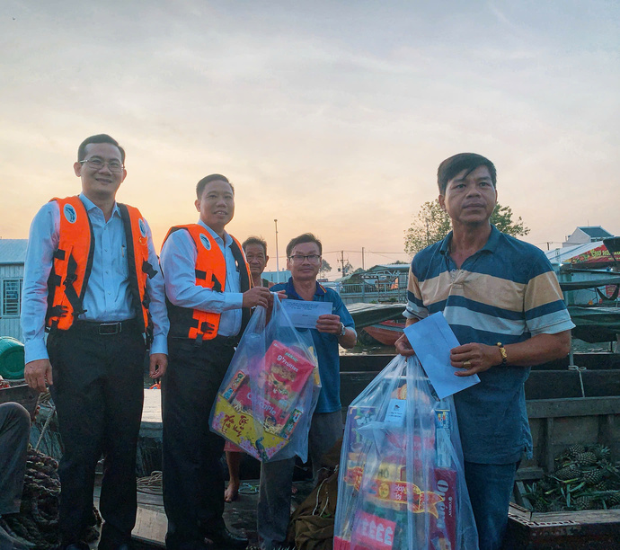 Ông Nguyễn Thực Hiện (thứ hai, trái)- Phó Chủ tịch UBND thành phố Cần Thơ cùng ông Nguyễn Minh Tuấn (ngoài cùng, trái)- Giám đốc Sở Văn hóa, Thể thao và Du lịch thành phố Cần Thơ, trao quà cho tiểu thương tại chợ nổi Cái Răng nhân dịp Tết Ất Tỵ 2025. Ảnh: Kiều Mai