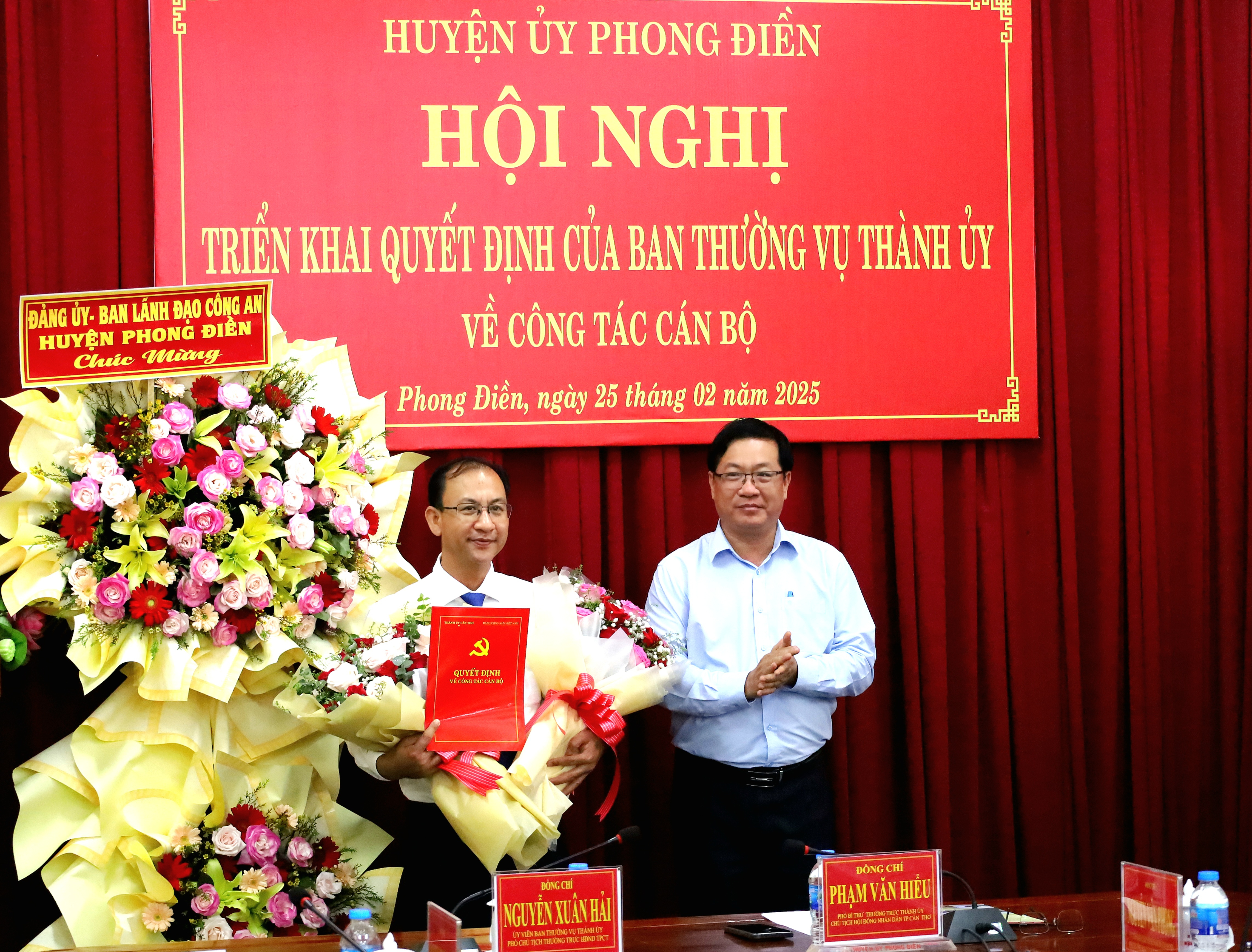 Ông Trần Lê Bình - Phó Bí thư thường trực Huyện ủy Phong Điền tặng hoa chúc mừng ông Nguyễn Trung Nghĩa - Bí thư Huyện ủy, Chủ tịch UBND huyện Phong Điền.