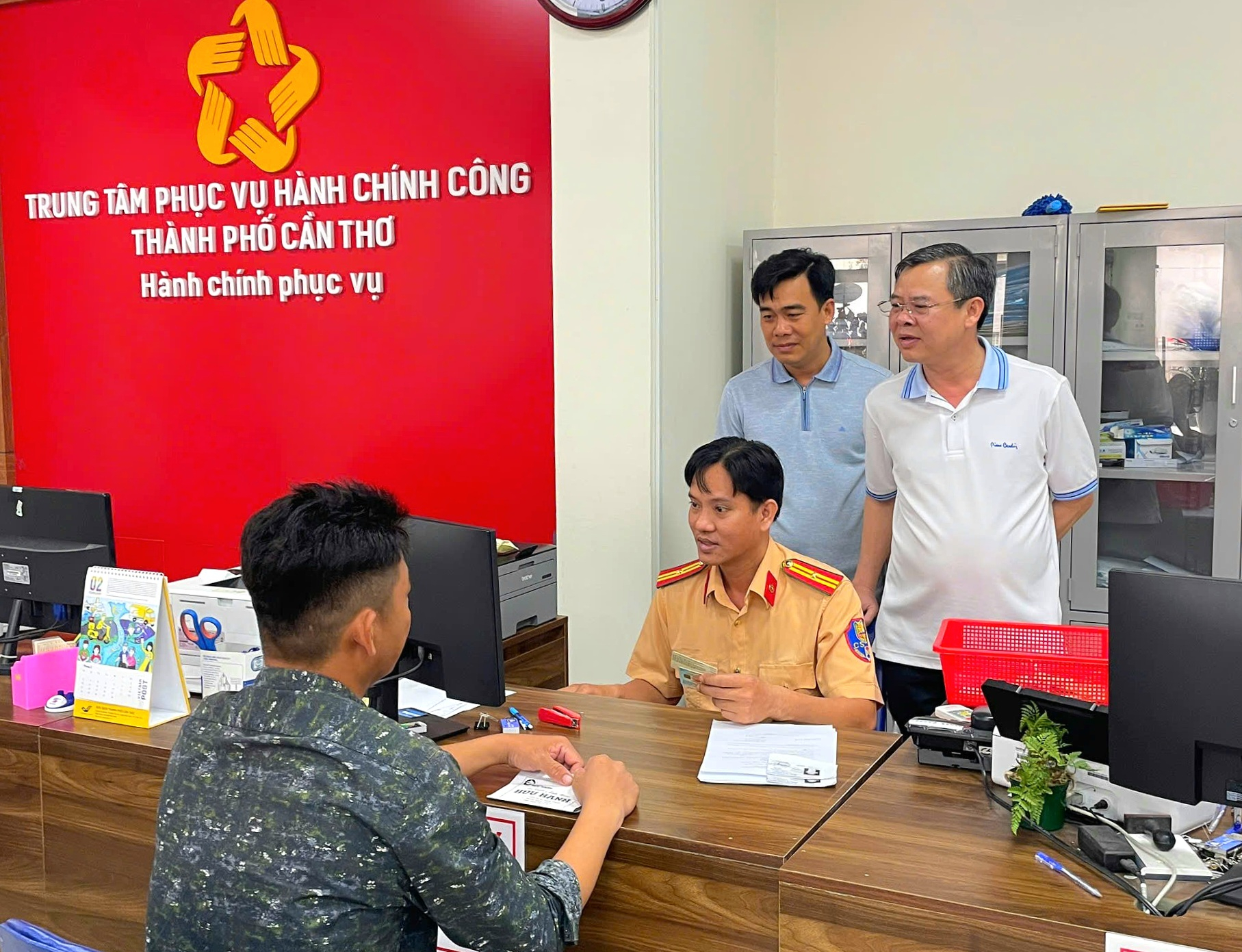 Ông Trương Cảnh Tuyên (bìa phải) - Phó Bí thư Thành ủy, Chủ tịch UBND TP. Cần Thơ trực tiếp theo dõi quá trình cán bộ Phòng Cảnh sát giao thông - Công an TP. Cần Thơ xử lý hồ sơ của người dân. Ảnh: TTPVHCC.