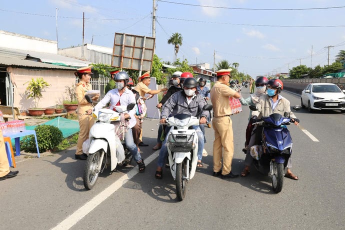 Lực lượng Cảnh sát giao thông, Công an tỉnh Sóc Trăng phát nước suối cho bà con về quê dịp Lễ.