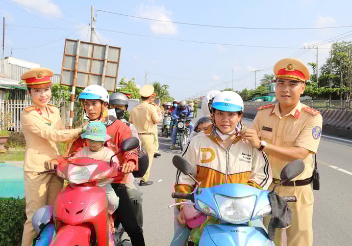 Lực lượng Cảnh sát giao thông phát nón bảo hiểm cho bà con về quê dịp Lễ.