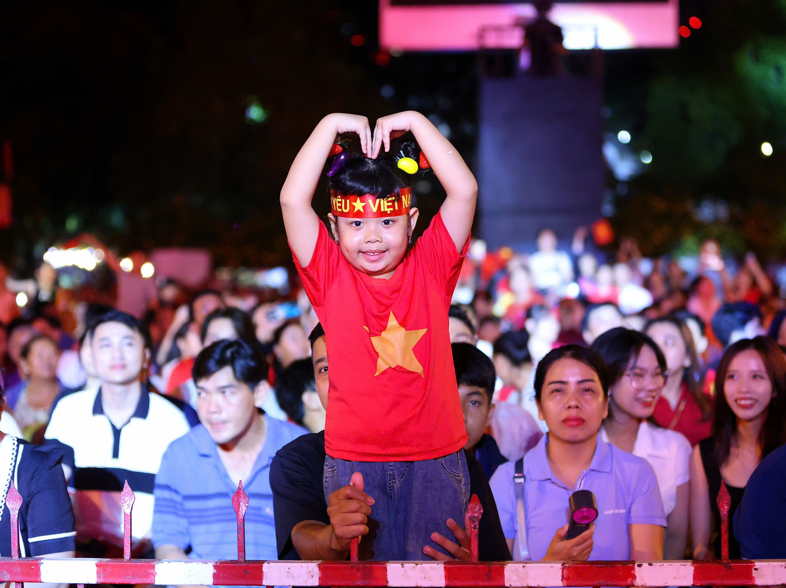 Một em bé thích thú được xem biểu diễn pháo hoa nghệ thuật.