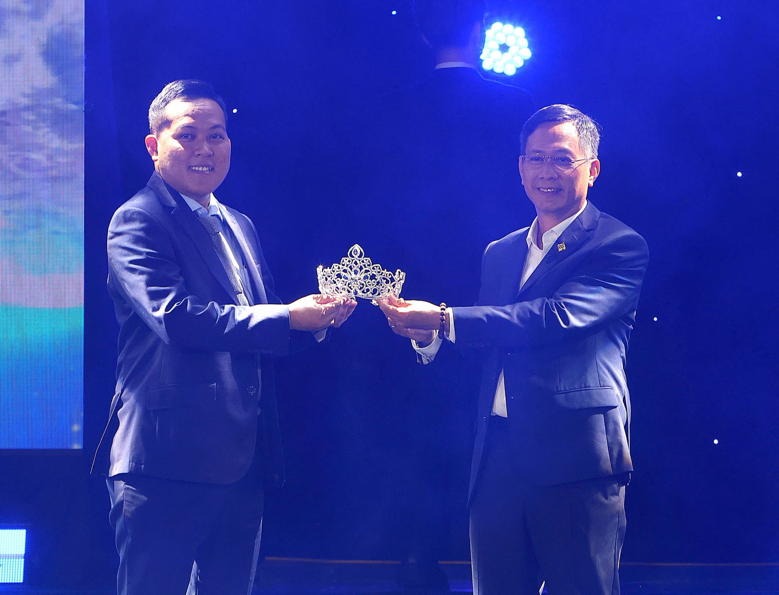 Ông Nguyễn Ngọc Huy - Giám đốc PNJ Chi nhánh Miền Tây thực hiện nghi thức bàn giao Vương miện cho ông Nguyễn Trí Đạt - Ủy viên Hội đồng Trường, Trường Đại học Nam Cần Thơ; Phó Tổng Giám đốc Công ty TNHH MTV TM Nam Cần Thơ DNC.