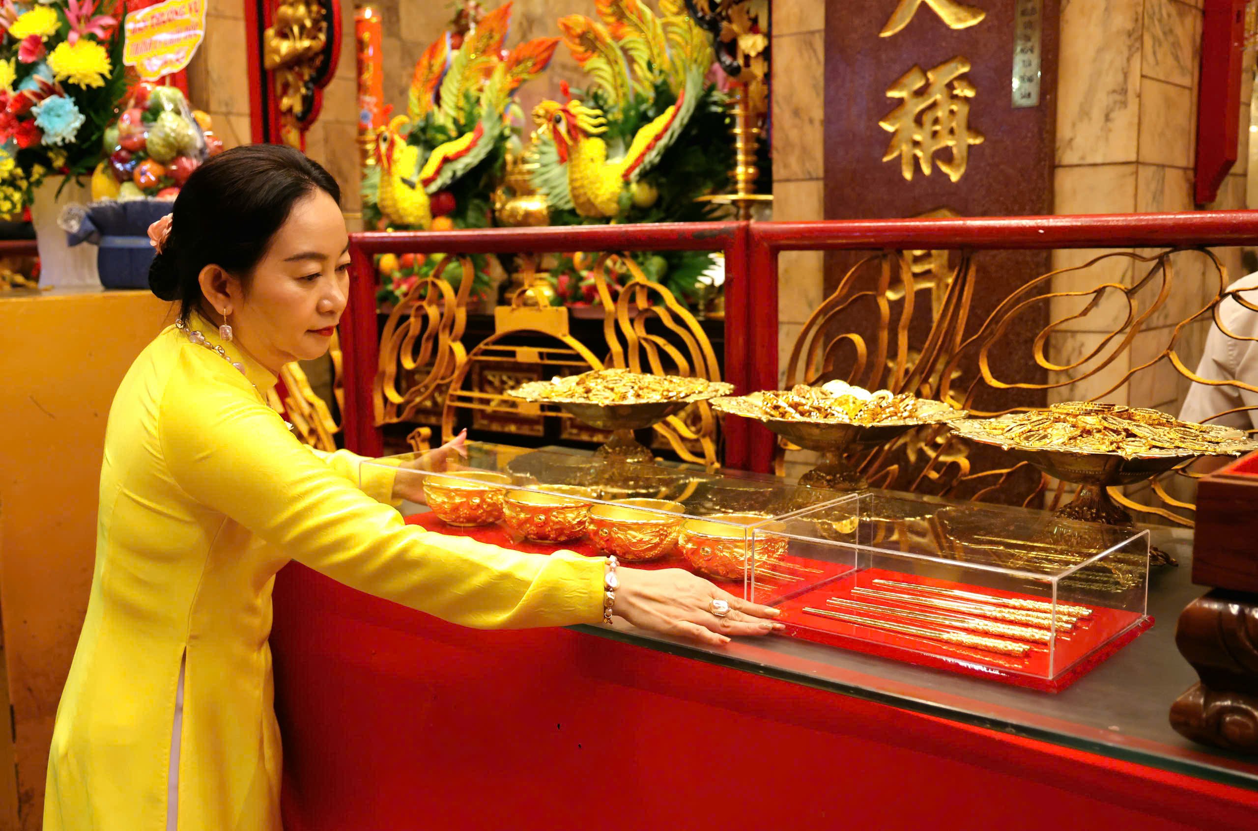 Bà Nguyễn Thị Ánh Vương - Đội trưởng Đội thờ tự, Tổ trưởng Tổ tắm Bà cẩn thận đem nhiều vật dụng quý giá của khách dâng cúng Bà.