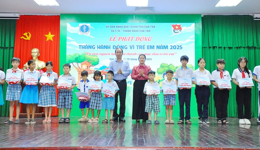 Bà Nguyễn Thị Ngọc Điệp, Phó Chủ tịch UBND thành phố và ông Phạm Phú Trường Giang, Phó Giám đốc Sở Y tế, trao học bổng và các suất quà cho các em thiếu nhi tại lễ phát động.