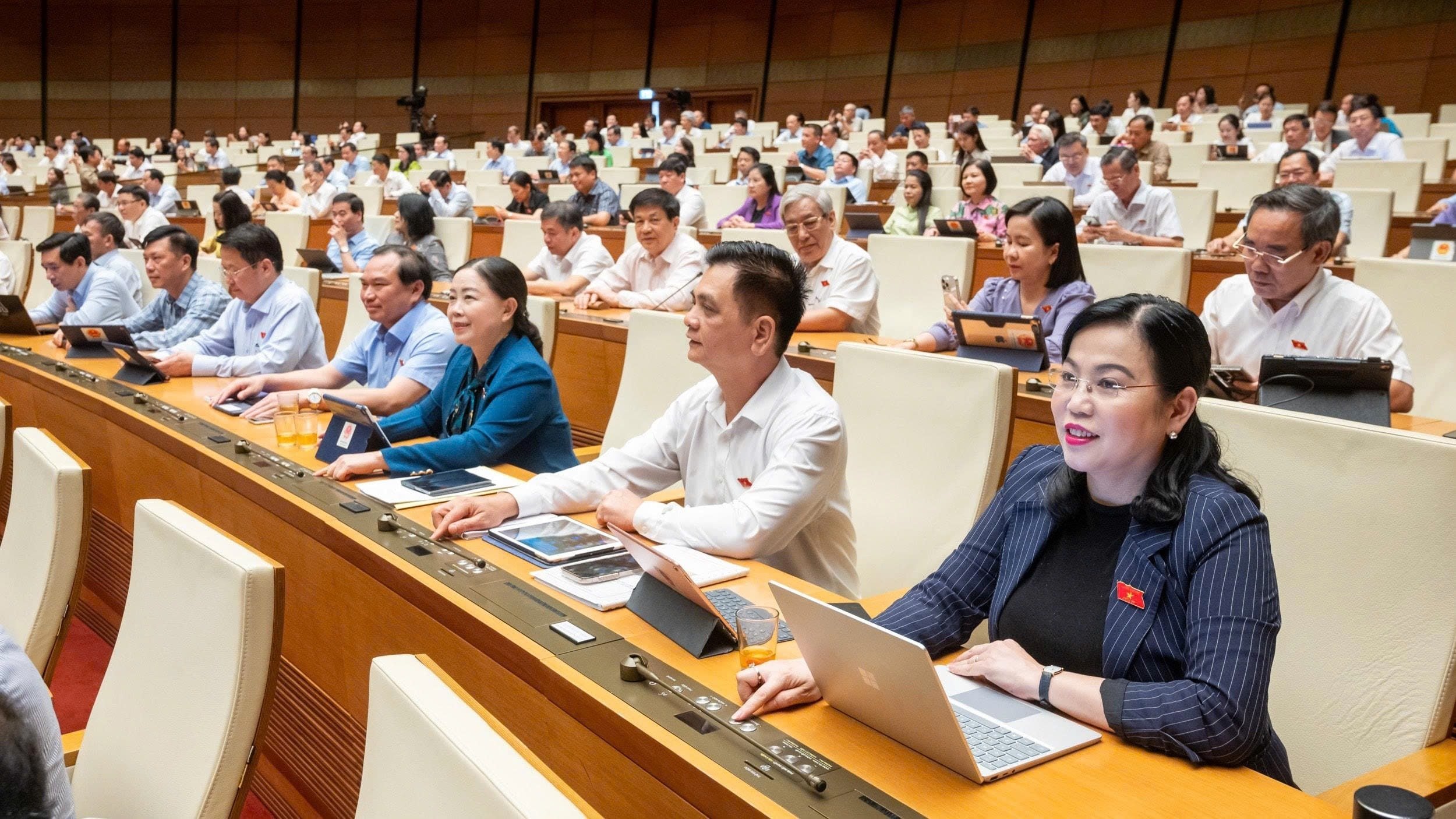 Các đại biểu Quốc hội bấm nút biểu quyết tại hội trường. Ảnh: Phạm Thắng.