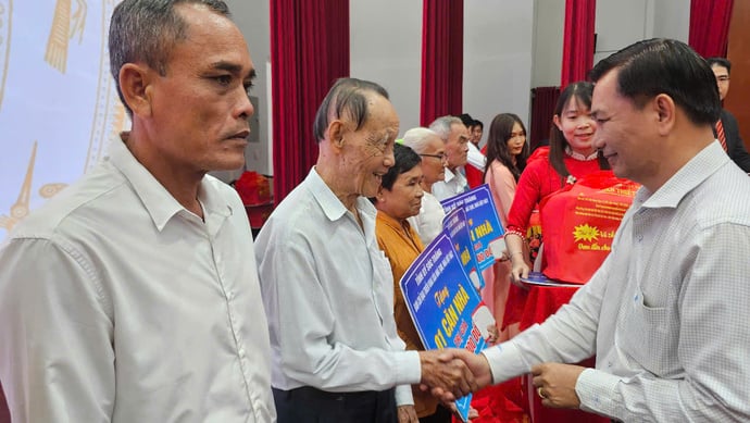 Ông Trần Văn Lâu, Chủ tịch UBND tỉnh tặng quà cho các hộ được nhận nhà tại hội nghị