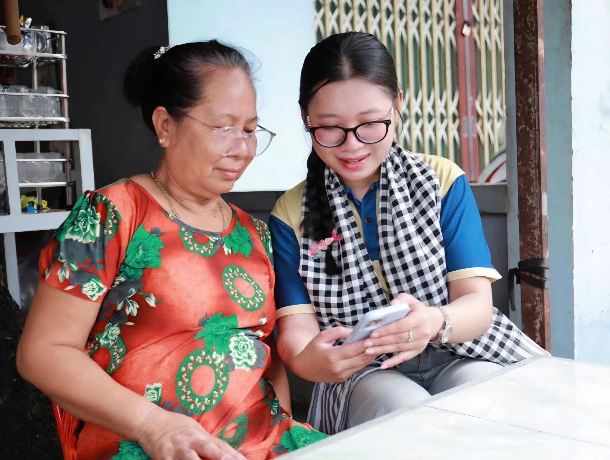 Sinh viên Trường Đại học Nam Cần Thơ hướng dẫn người dân cài đặt ứng dụng số.