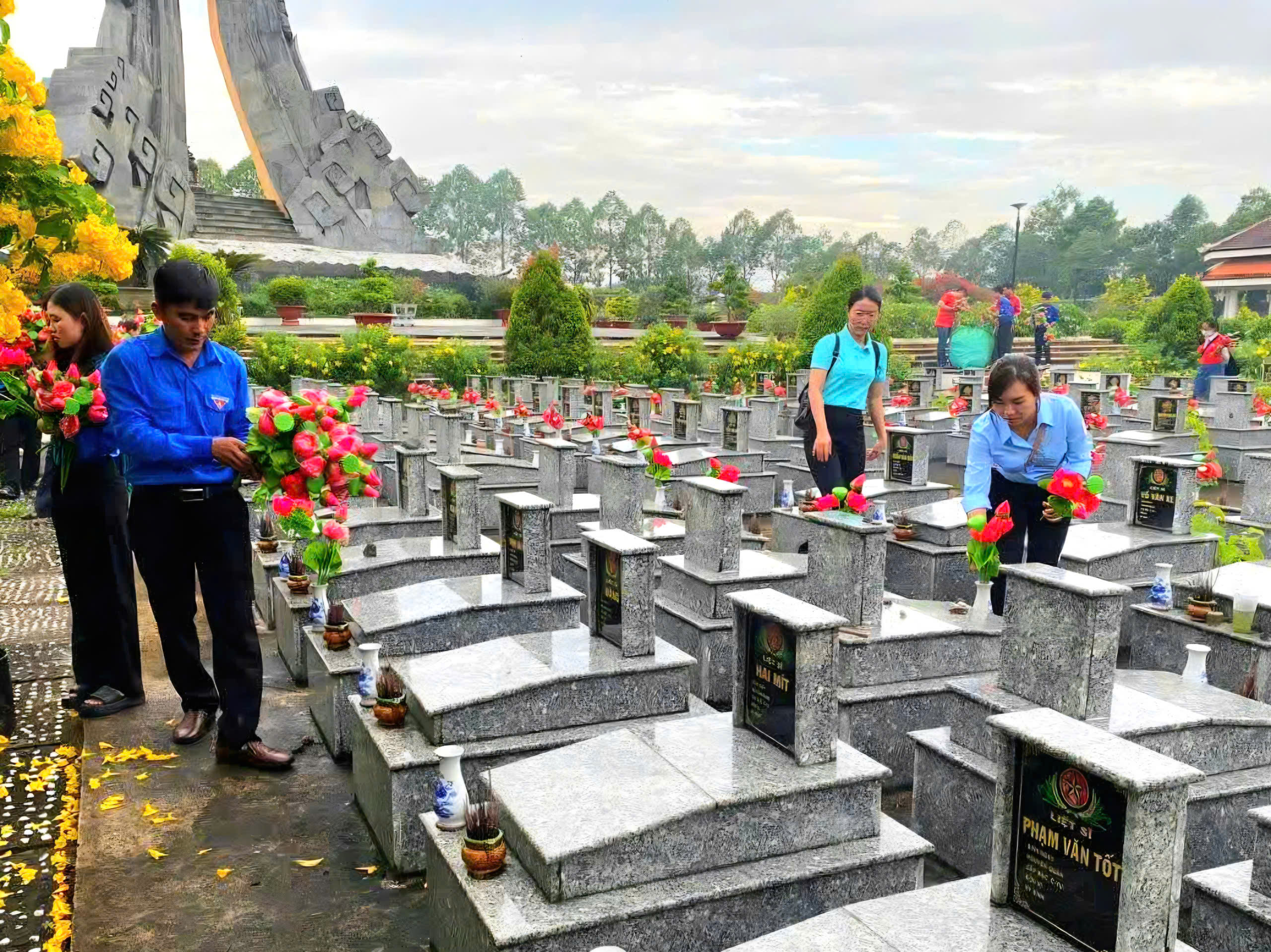 Tiến hành thay hoa tại phần mộ liệt sĩ.