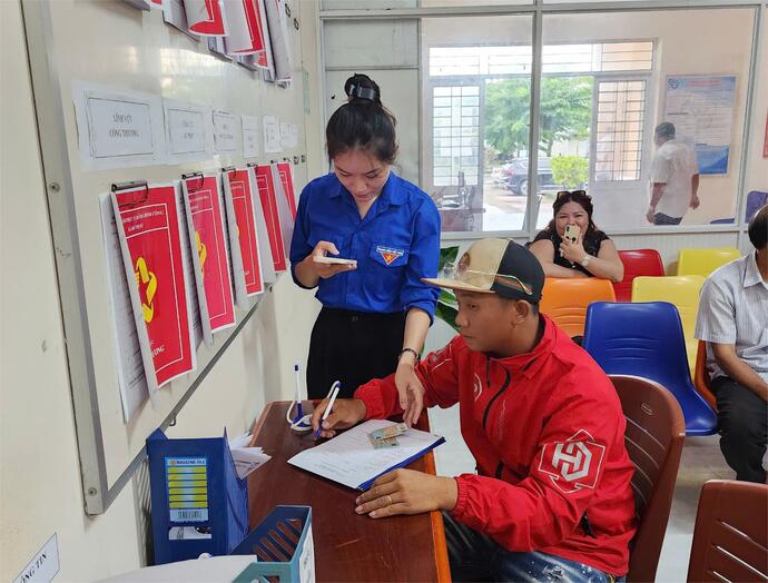 Cán bộ Trung tâm và lực lượng đoàn thanh niên hướng dẫn, giúp người dân đăng nhập tài khoản để thực hiện nộp hồ sơ trực tuyến.