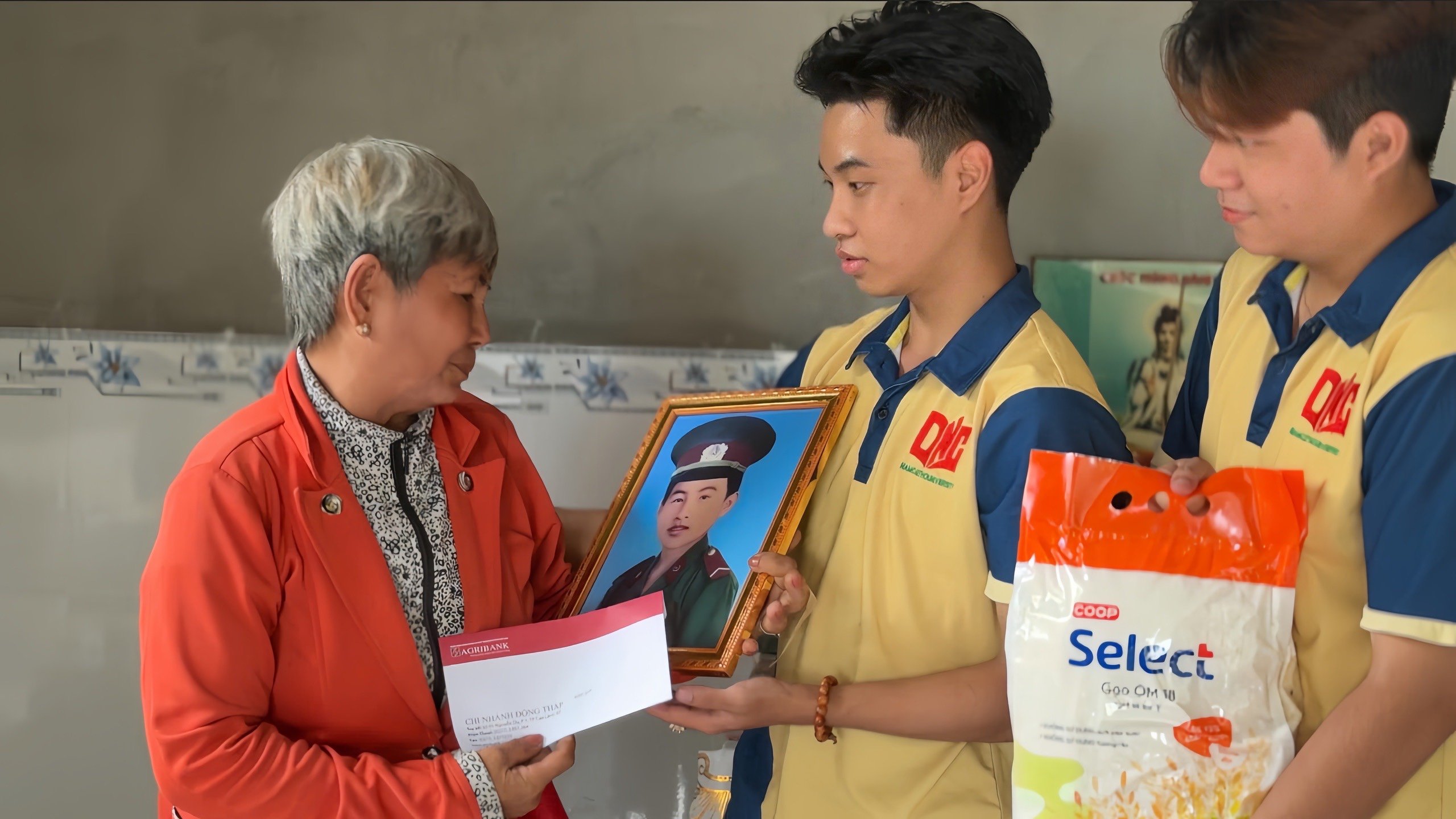 Gia đình liệt sĩ xúc đông khi nhận trên tay ảnh được phục dựng của liệt sĩ.