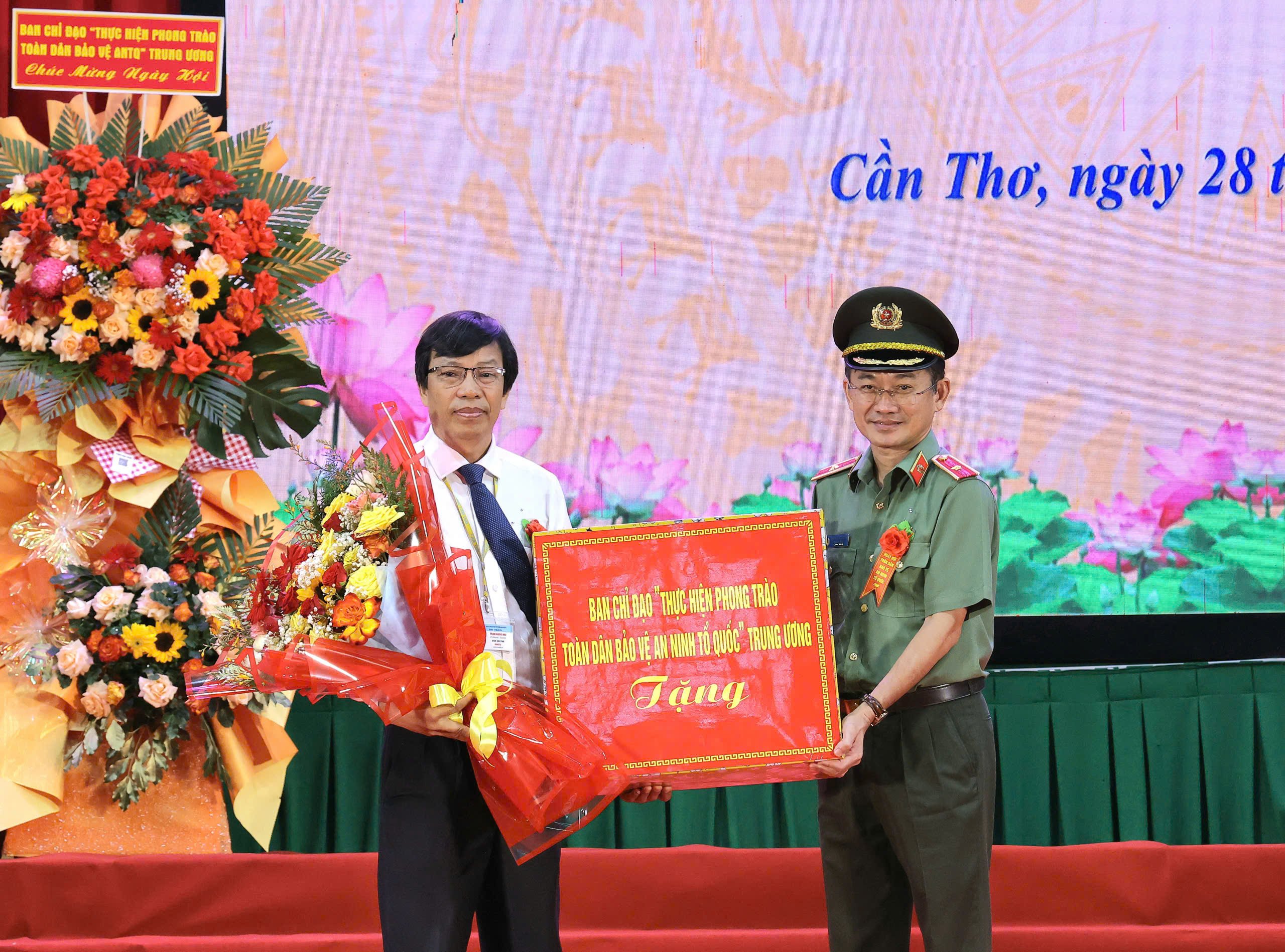 Thiếu tướng Trần Văn Dương - Cục trưởng Cục Xây dựng phong trào bảo vệ ANTQ, Bộ Công an trao hoa và quà tặng Ban Giám hiệu Đại học Cần Thơ.