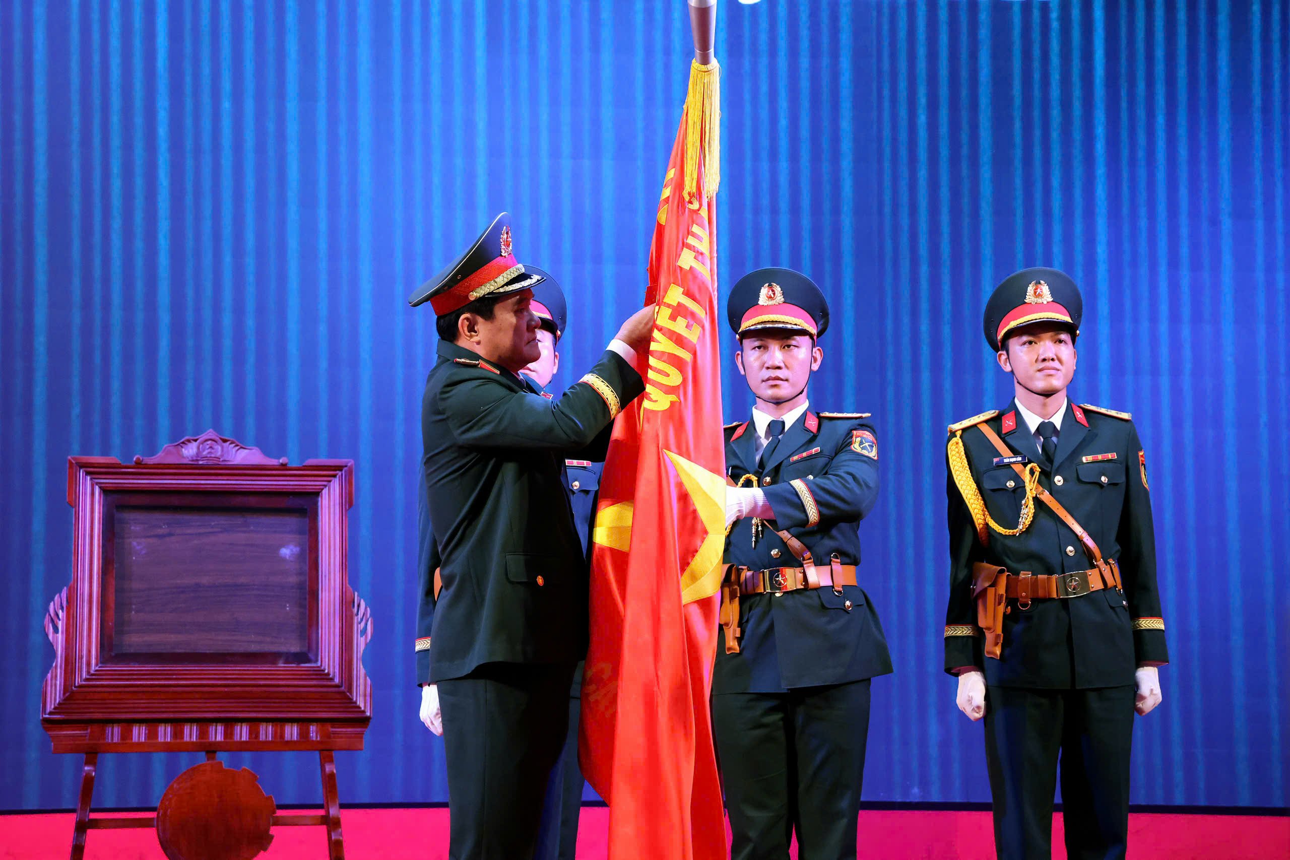 Trung tướng Nguyễn Xuân Dắt - Phó Bí thư Đảng ủy, Tư lệnh Quân khu 9 gắn Huân chương lên lá Cờ truyền thống.