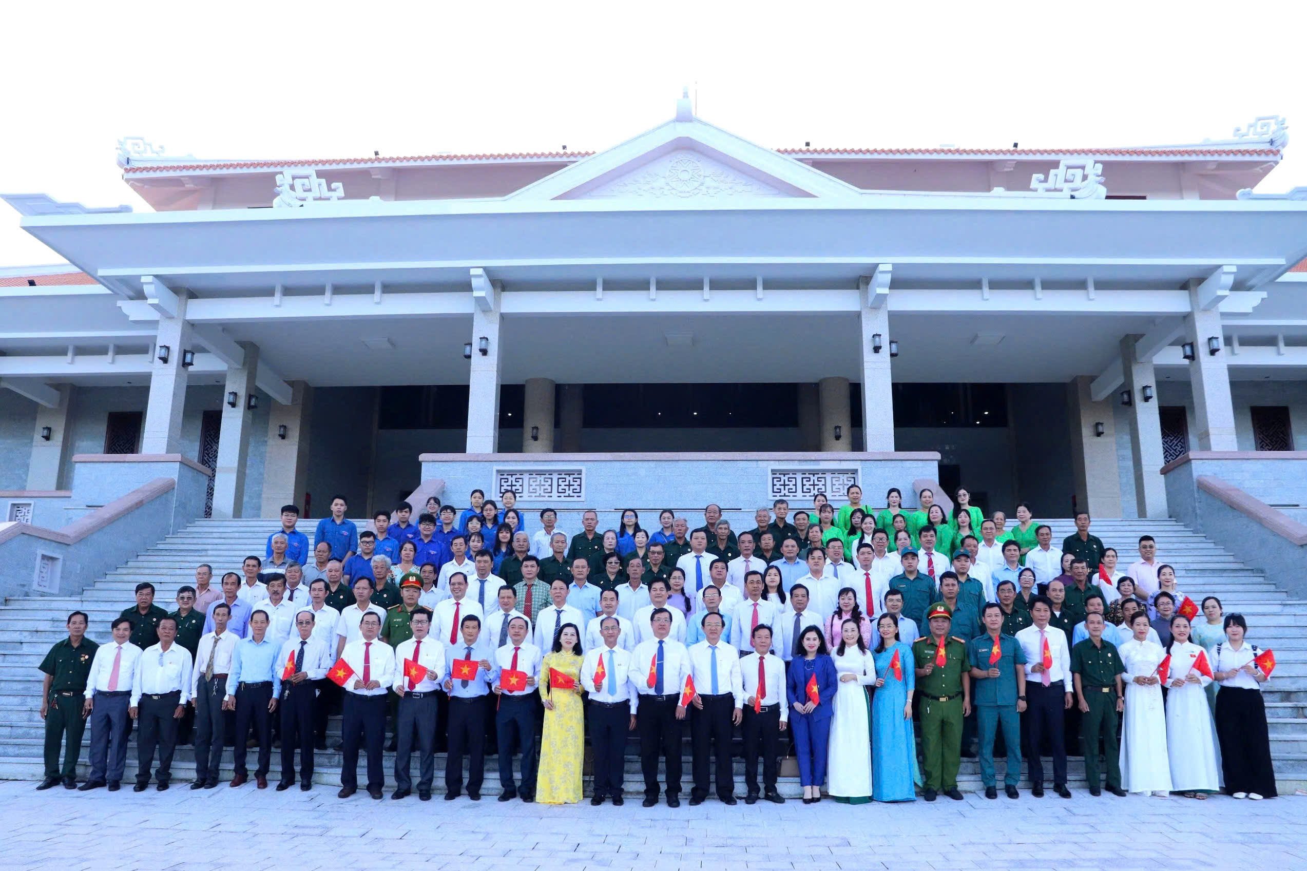 Các đại biểu chụp hình lưu niệm tại Di tích lịch sử “Địa điểm chuyển quân, Trạm Quân y Tiền phương và nơi cất giấu vũ khí thuộc Lộ Vòng Cung Cần Thơ trong kháng chiến chống Mỹ”.
