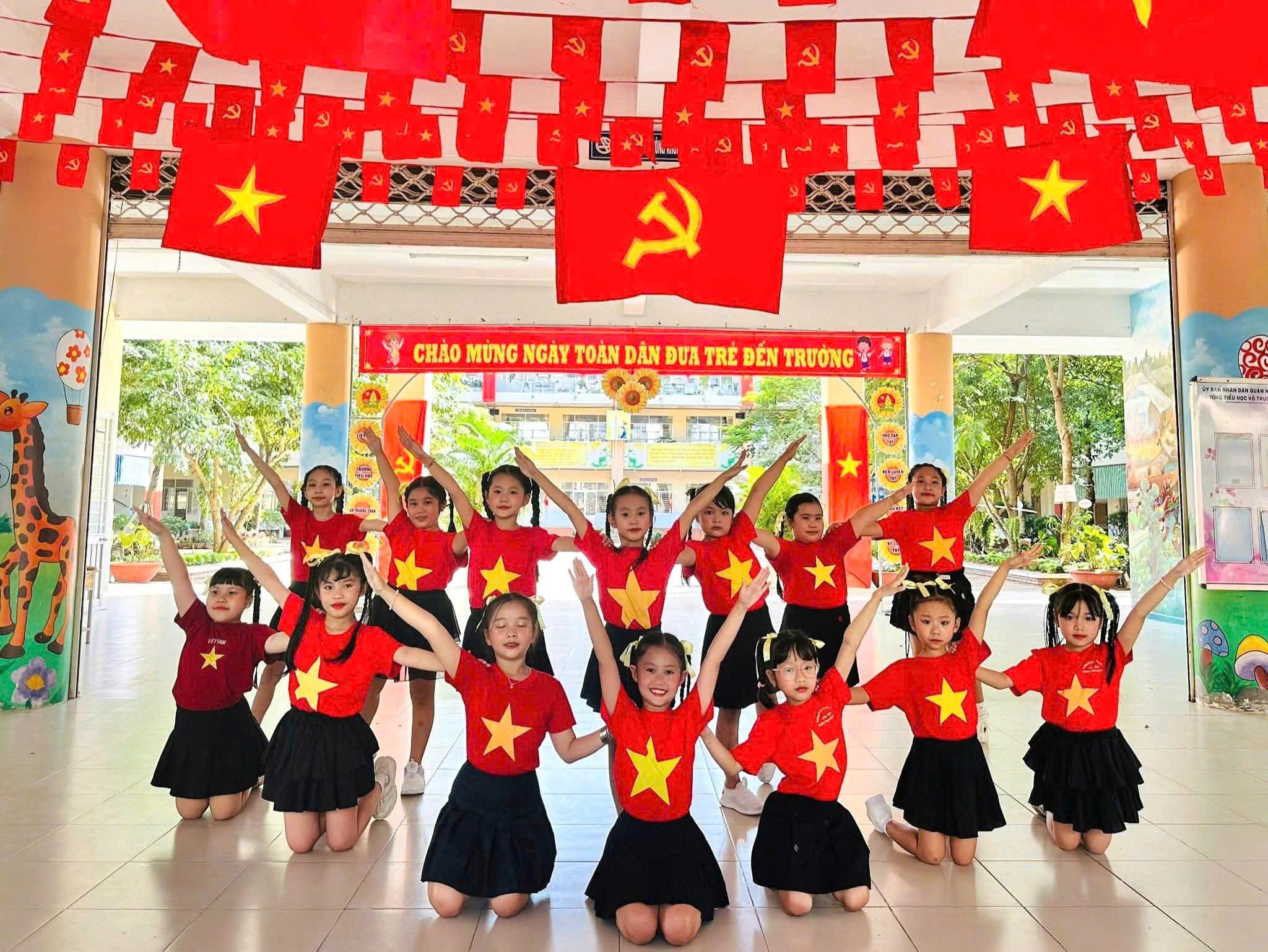 Học sinh Trường Tiểu học Võ Trường Toản, phường Cái Khế thích thú trước màu đỏ rực của cờ đỏ sao vàng.