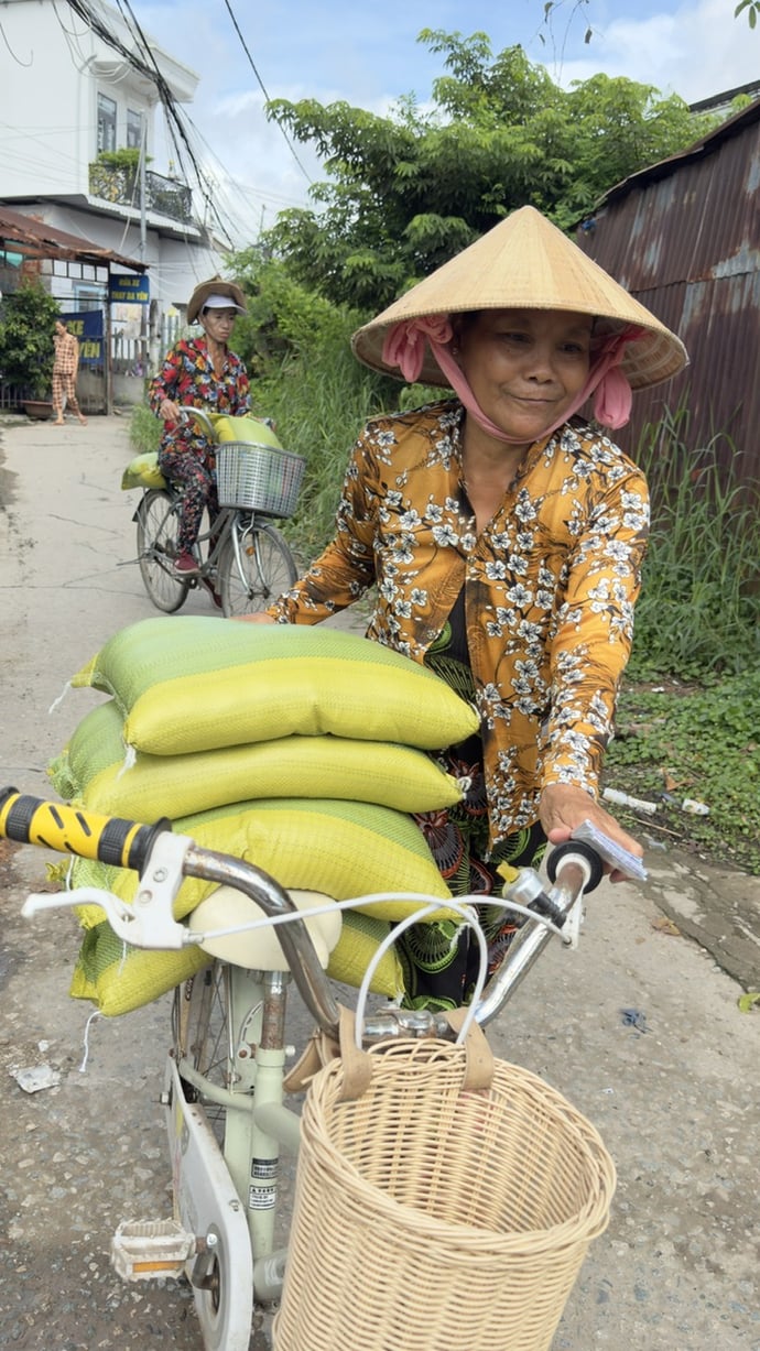 Bà Ngọc Diệu, khu vực 7 phường Hưng Phú (TP Cần Thơ), nhận phần gạo của mình và nhận giúp cho các hộ nghèo đang mưu sinh làm thuê ở xa chưa kịp về.