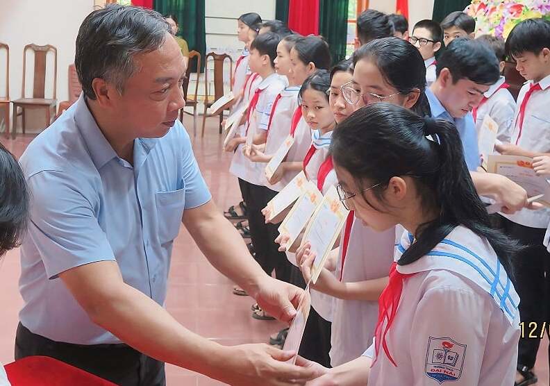 Ông Lê Trọng Minh, Tổng biên tập Báo Đầu tư trao tặng học bổng cho các em học sinh.