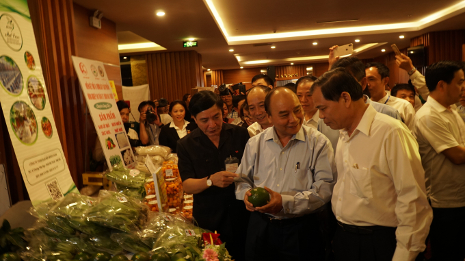 Thủ tướng Nguyễn Xuân Phúc và Bộ trưởng Bộ NN-PTNT tham quan gian hàng nông sản của người dân. Ảnh: TA.