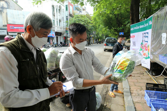 Mr. Do Ba Tu, business manager of six booths, checks the arrival of the vegetables at a booth with Mr. Tran Ngoc Tuan. According to Mr. Tu, inventory management must be meticulous, guaranteeing that when items are out of stock shipping suppliers can be contacted quickly.