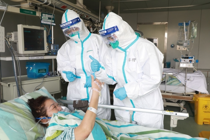 Nhân viên y tế tại bệnh viện Trung Nam thuộc Đại học Vũ Hán chăm sóc một bệnh nhân nhiễm nCoV đang hồi phục. Ảnh: China Daily.