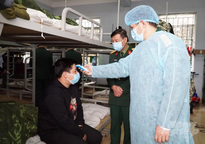 Sau khi tiếp nhận công dân Việt Nam trở về từ Trung Quốc sẽ có cán bộ y tế tiến hành kiểm tra sức khỏe. Ảnh: Kông Hải.