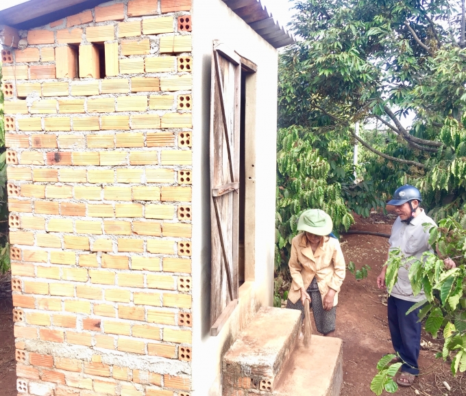 Cán bộ thôn Hiệp Hưng (phải) hướng dẫn người dân cách sử dụng và vệ sinh đối với nhà tiêu hợp vệ sinh. Ảnh: Trung Dũng.