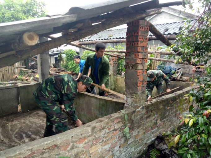 Đồn biên phòng Quảng Đức giúp nhân dân bản Vắn Tốc, xã Quảng Đức vệ sinh chuồng trại chăn nuôi.