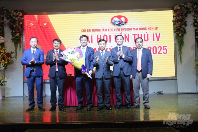 Phó Bí thư Thường trực Đảng ủy Bộ NN-PTNT Nguyễn Văn Trường (thứ 3 từ phải sang) tặng hoa chúc mừng Ban chấp hành Chi ủy nhiệm kỳ 2020-2025 của Trung tâm XTTM Nông nghiệp. Ảnh: Lê Bền.