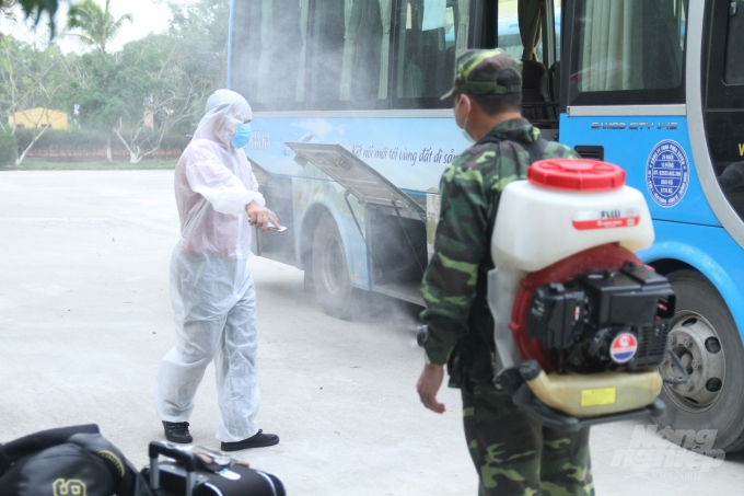 Nhân viên y tế và lái xe, người trực tiếp vận chuyển công dân từ sân bay Vân Đồn về khu vực cách ly đang trong quy trình khử trùng đặc biệt.