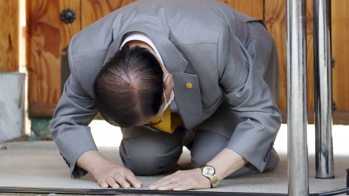 Giáo chủ Tân Thiên Địa Lee Man-hee quỳ gối xin lỗi tại cuộc họp báo hôm 2/3. Ảnh: Yonhap.