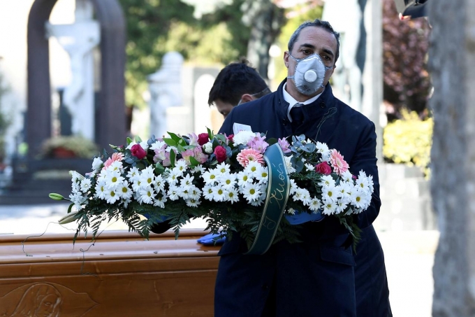 Nhân viên tang lễ di chuyển quan tài của một bệnh nhân chết vì nCoV vào nghĩa trang ở Bergamo, Italy, ngày 16/3. Ảnh: Reuters.