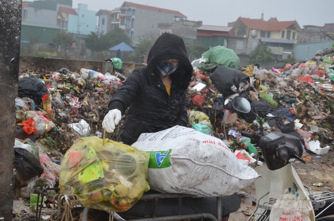 Một người dân chở rác ra đổ ở bãi của thôn. Ảnh: Dương Đình Tường.