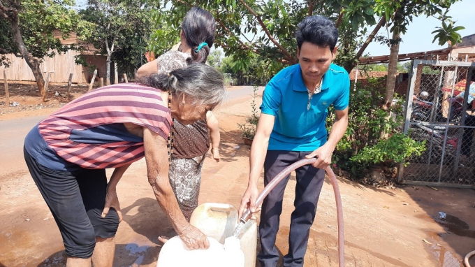 Anh Điểu Điết vui vẻ tiếp nước cho bà con trong thôn. Ảnh: Trần Trung.