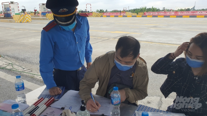 Lực lượng chức năng hướng dẫn 1 công dân người Trung Quốc thực hiện các yêu cầu phòng chống dịch theo quy định tại chốt số 3. Ảnh: Đinh Mười.