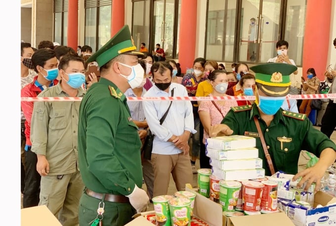 Công dân Việt Nam làm thủ tục nhập cảnh qua CKQT Cha Lo được tặng bánh mì và một số nhu yếu phẩm cần thiết. Ảnh: T.P.