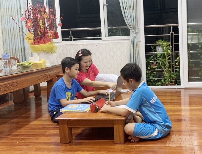Chị Lê Thị Vân (quận 1) hướng dẫn các con cùng ôn bài trong thời gian nghỉ dịch. Ảnh: Thùy Lâm.