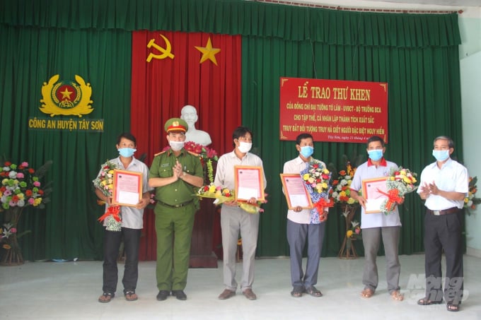 Đại tá Nguyễn Đức Nam, Phó Giám đốc Công an tỉnh Bình Định, trao Thư khen cùng tiền thưởng cho 4 công dân bắt được đối tượng truy nã đặc biệt. Ảnh: Vũ Đình Thung.