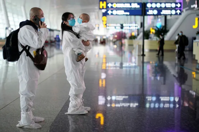 Hành khách mặc đồ bảo hộ tại sân bay quốc tế Thiên Hà Vũ Hán, thành phố Vũ Hán, sau khi lệnh phong tỏa được dỡ bỏ. Ảnh: Reuters.