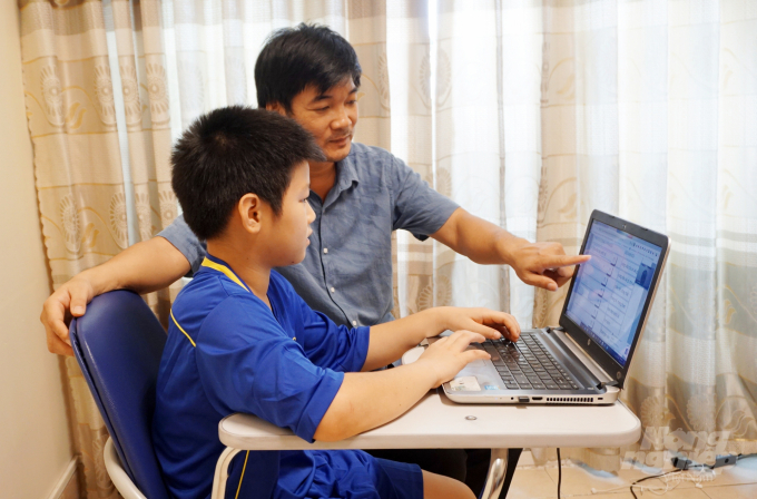 Trong thời gian nghỉ dịch ở nhà, phụ huynh luôn phải thường xuyên 'học' cùng con trên internet. Ảnh: Nguyễn Thủy.