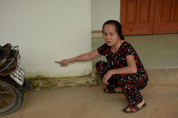 Bà Lê Thị Kim Thê chỉ ngấn nước ngập nhà bà. Ảnh: Thái Sinh.