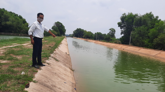 Cán bộ nông nghiệp địa phương kiểm tra lưu lượng nước trên kênh. Ảnh: Trần Trung.