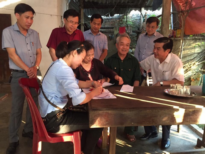 Ông Đặng Quốc Vinh (áo trắng ngồi bên phải), Phó Chủ tịch UBND tỉnh Hà Tĩnh kiểm tra, giám sát công tác chi trả tiền hỗ trợ gói 62.000 tỷ đồng ở huyện Hương Khê. Ảnh: Gia Hưng.
