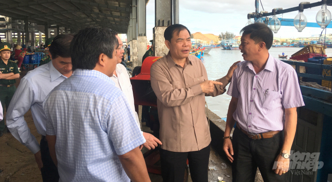 Bộ trưởng Bộ NN-PTNT Nguyễn Xuân Cường (thứ 2 từ phải sang) kiểm tra công tác kiểm soát tàu cá ra vào cảng tại Cảng cá Quy Nhơn (Bình Định). Ảnh: Vũ Đình Thung.