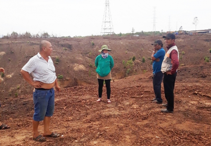 Hai người con của bà Mai (trái) ngăn cản công nhân của dự án Phú An Lành thi công trên đất của bà Mai.