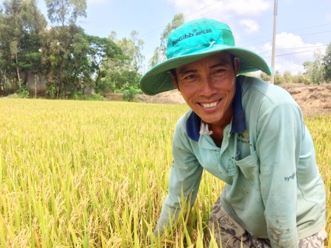 Tỷ phú Đặng Minh Vương bên ruộng lúa của mình. Ảnh: Thanh Bình.